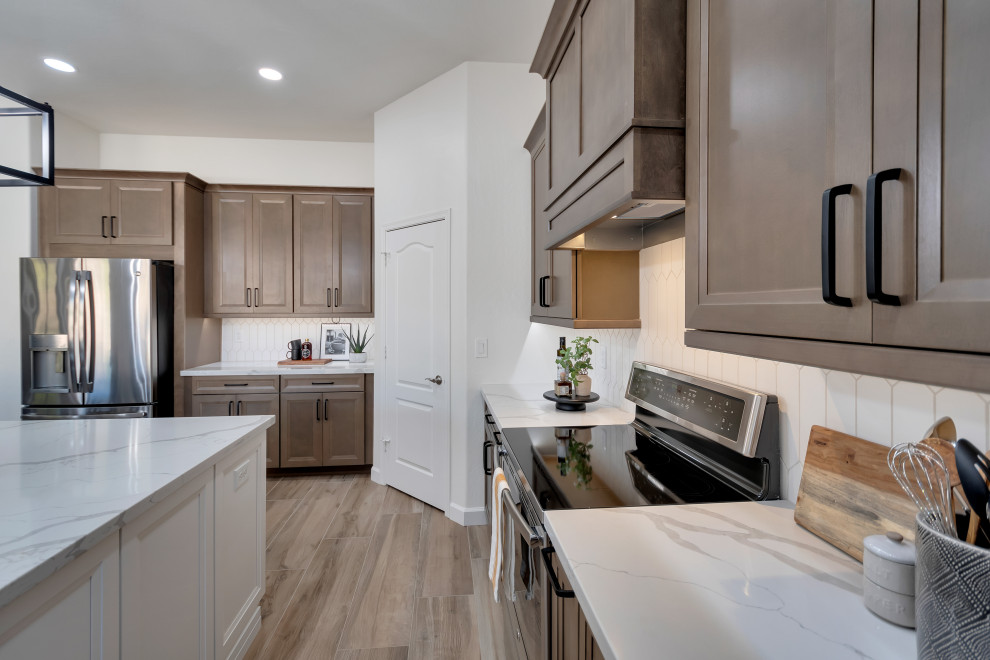 Mid-sized transitional u-shaped ceramic tile and brown floor eat-in kitchen photo in Phoenix with beaded inset cabinets, brown cabinets, quartzite countertops, white backsplash, ceramic backsplash, an island and white countertops