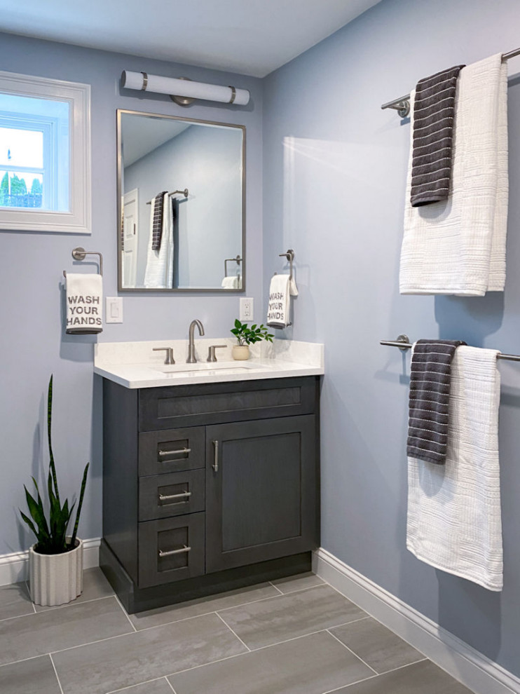 Inspiration for a transitional white tile and ceramic tile porcelain tile, gray floor and single-sink corner shower remodel in Boston with shaker cabinets, gray cabinets, a one-piece toilet, gray walls, an undermount sink, quartz countertops, a hinged shower door, white countertops and a built-in vanity