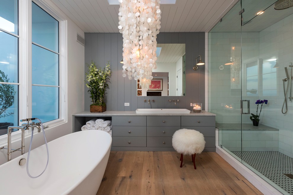 Alcove shower - large transitional master white tile and subway tile medium tone wood floor alcove shower idea with flat-panel cabinets, gray cabinets, white walls, a trough sink and quartz countertops
