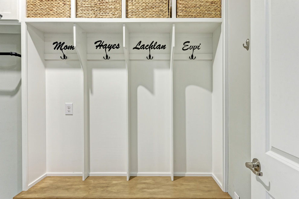 This is an example of a large country galley dedicated laundry room in Tampa with white cabinets, ceramic floors, a side-by-side washer and dryer and grey floor.