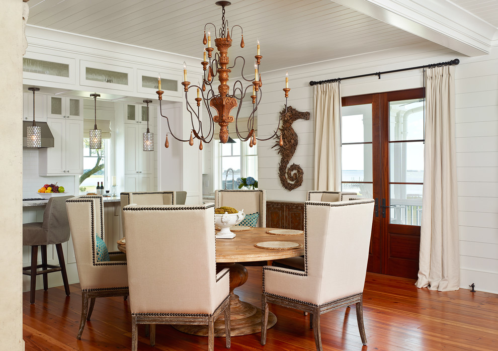 This is an example of a tropical kitchen/dining combo in Charleston with white walls and dark hardwood floors.