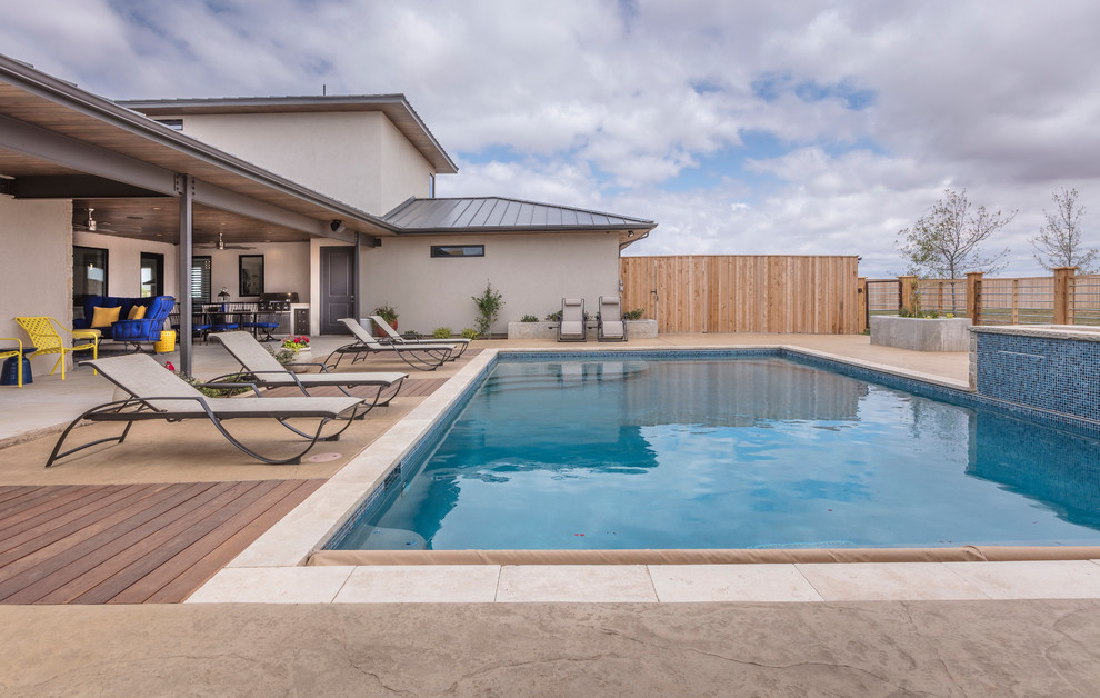 Example of a large transitional backyard stamped concrete and rectangular lap hot tub design