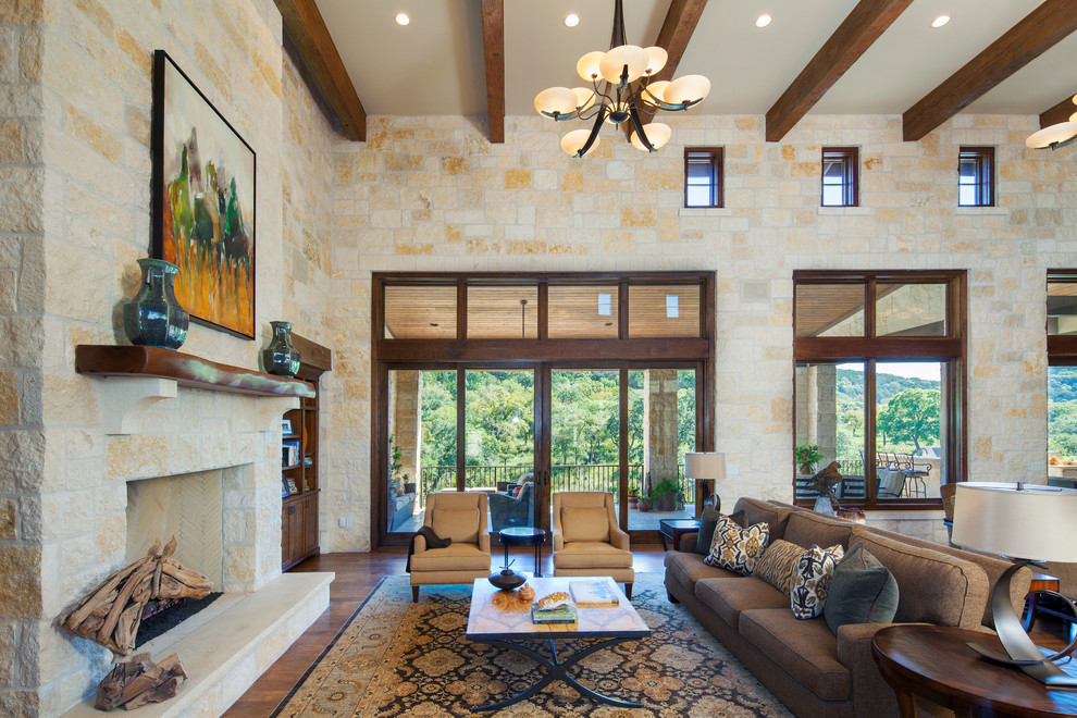 This is an example of a country open concept living room in Austin with a stone fireplace surround.