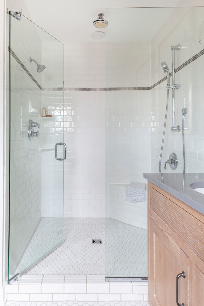Photo of a mid-sized transitional master bathroom in Chicago with shaker cabinets, light wood cabinets, an alcove shower, a two-piece toilet, white tile, grey walls, ceramic floors, a drop-in sink, engineered quartz benchtops, white floor, a hinged shower door, grey benchtops, a double vanity and a freestanding vanity.