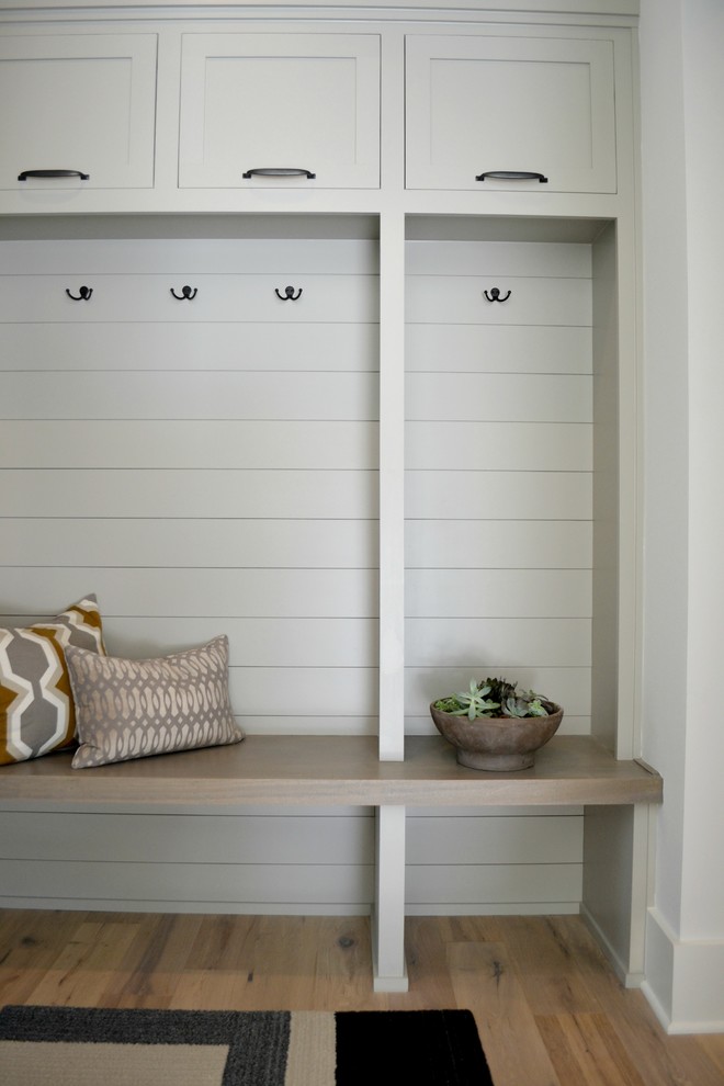 Mid-sized country mudroom in Indianapolis with white walls and medium hardwood floors.