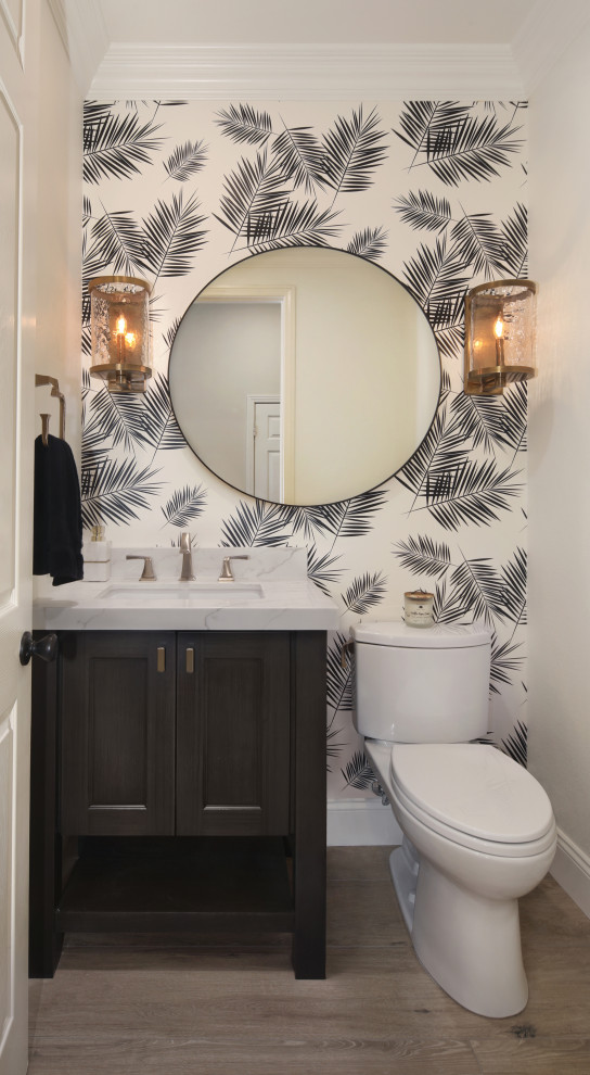 Transitional powder room in Los Angeles with shaker cabinets, black cabinets, a two-piece toilet, white walls, medium hardwood floors, an undermount sink, marble benchtops, brown floor and multi-coloured benchtops.