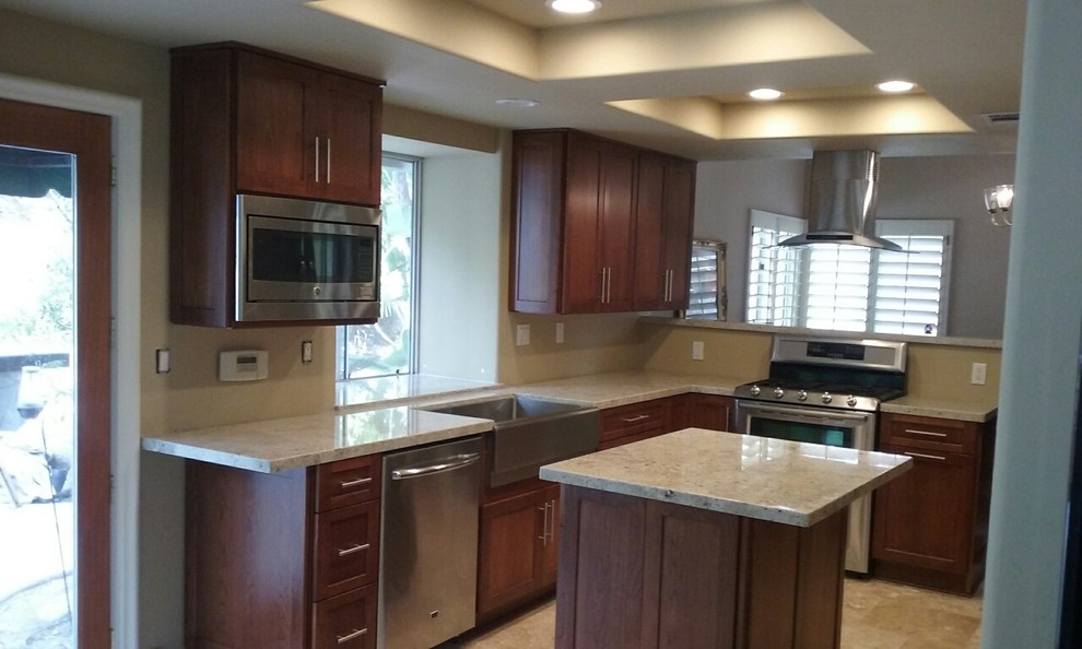 Example of a mid-sized minimalist u-shaped travertine floor and beige floor eat-in kitchen design in San Diego with a farmhouse sink, shaker cabinets, brown cabinets, quartzite countertops, stainless steel appliances and an island