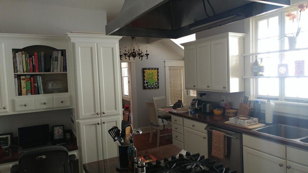 Example of a mid-sized transitional l-shaped dark wood floor and brown floor enclosed kitchen design in Charlotte with a double-bowl sink, shaker cabinets, white cabinets, granite countertops, stainless steel appliances and an island
