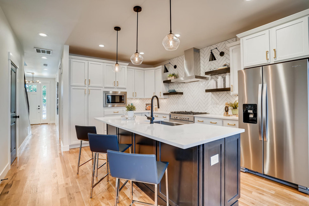 Example of a mid-sized transitional medium tone wood floor eat-in kitchen design in Denver with a farmhouse sink, shaker cabinets, white cabinets, quartzite countertops, white backsplash, subway tile backsplash, stainless steel appliances, an island and white countertops