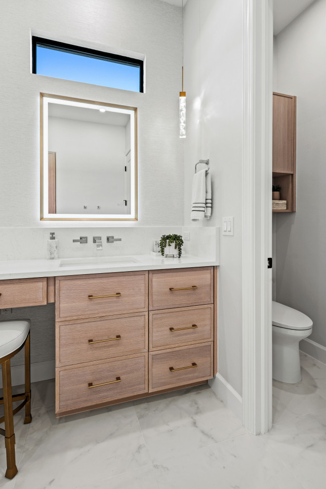 Transitional master gray tile and porcelain tile porcelain tile, white floor and double-sink walk-in shower photo with shaker cabinets, light wood cabinets, a two-piece toilet, white walls, an undermount sink, quartz countertops, white countertops, a niche and a built-in vanity