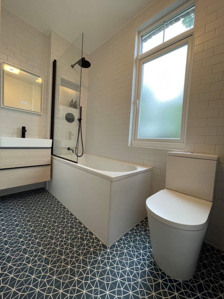 Inspiration for a small contemporary kids' white tile and porcelain tile porcelain tile, blue floor and single-sink bathroom remodel in London with flat-panel cabinets, light wood cabinets, a two-piece toilet, white walls, a wall-mount sink, a hinged shower door and a floating vanity