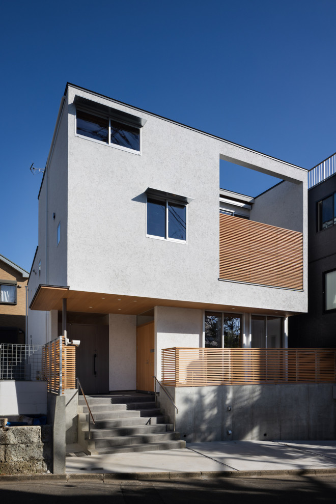 Large and white modern two floor render semi-detached house in Tokyo with a lean-to roof, a metal roof and a grey roof.