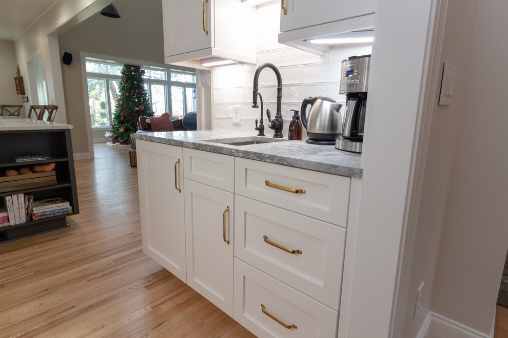 Example of a large l-shaped eat-in kitchen design with shaker cabinets, white cabinets, granite countertops, an island and white countertops