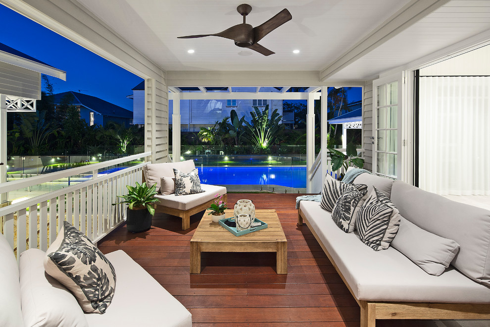 Design ideas for a mid-sized beach style backyard deck in Brisbane with a roof extension.