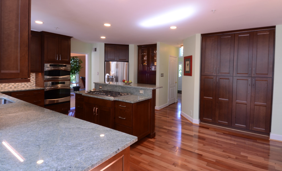 Inspiration for a mid-sized transitional l-shaped dark wood floor and brown floor eat-in kitchen remodel in Baltimore with shaker cabinets, dark wood cabinets, granite countertops, stainless steel appliances and an island