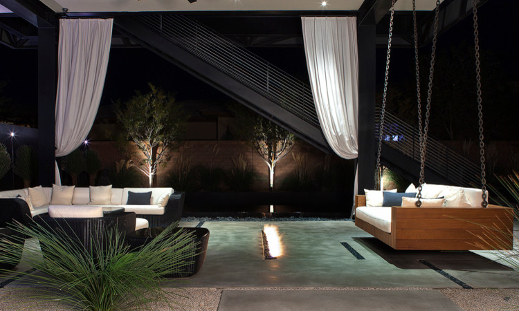 Photo of a large contemporary backyard patio in New York with concrete slab, a roof extension and a fire feature.