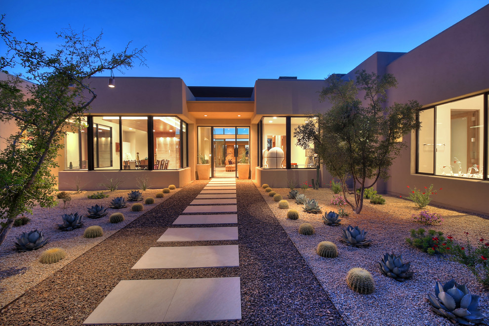 Contemporary full sun xeriscape in Other with a garden path and gravel.