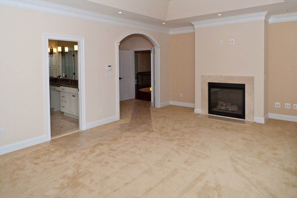 Photo of an expansive transitional master bedroom in DC Metro with beige walls, carpet and a standard fireplace.