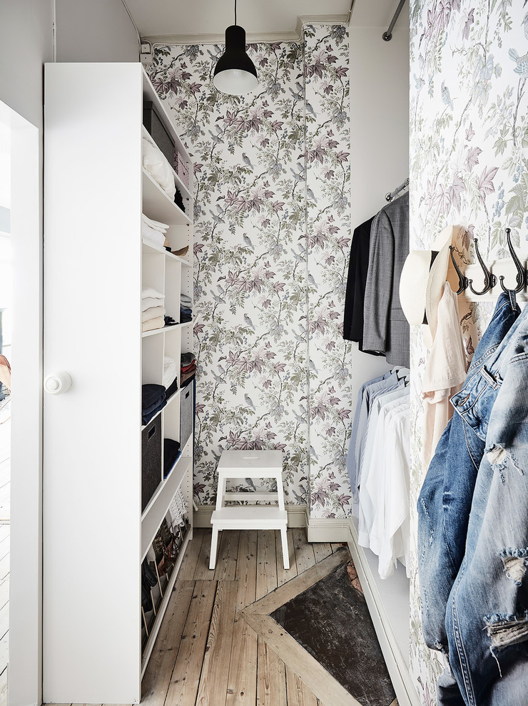 Design ideas for a mid-sized scandinavian gender-neutral walk-in wardrobe in Gothenburg with open cabinets and white cabinets.