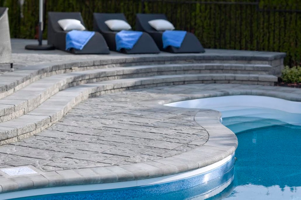 Large transitional backyard stone and custom-shaped pool photo in DC Metro