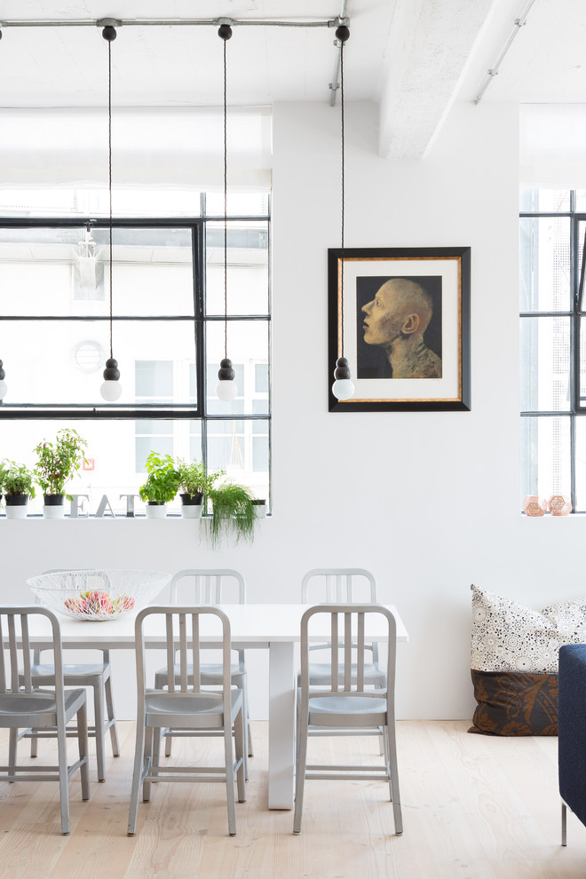 Photo of a scandinavian open plan dining in London with white walls and light hardwood floors.