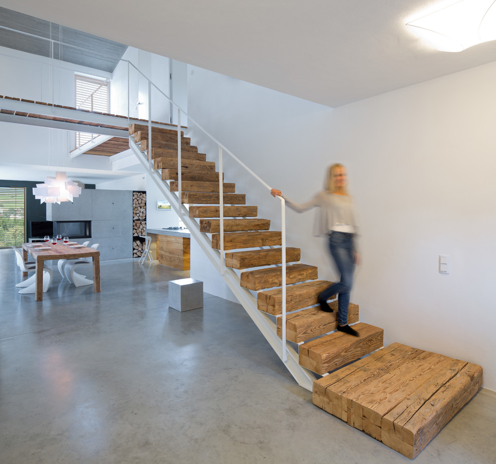 This is an example of a mid-sized contemporary wood straight staircase in Munich with metal railing.