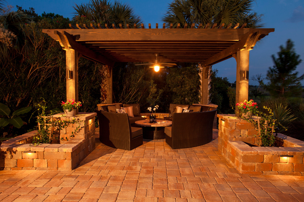 Photo of an expansive traditional backyard patio in Jacksonville with a fire feature, natural stone pavers and a pergola.