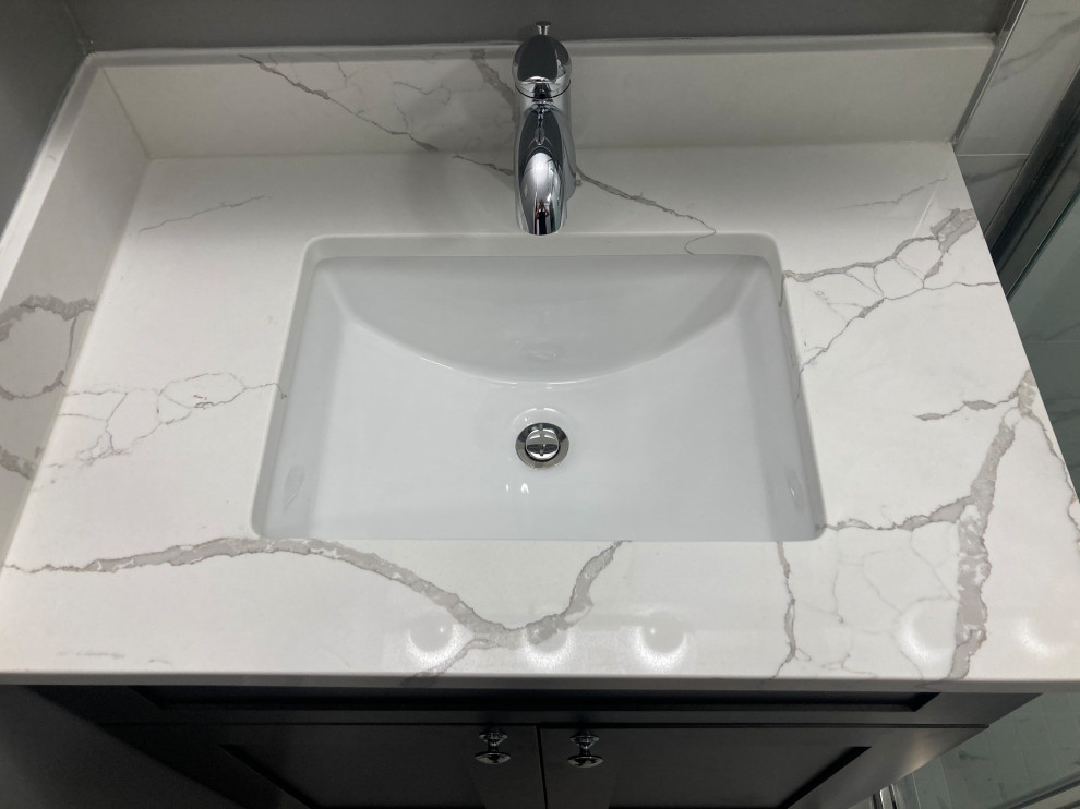 Photo of a small modern kids bathroom in DC Metro with shaker cabinets, grey cabinets, a corner shower, a two-piece toilet, white tile, porcelain tile, grey walls, porcelain floors, an undermount sink, quartzite benchtops, white floor, a hinged shower door, white benchtops, a single vanity and a built-in vanity.