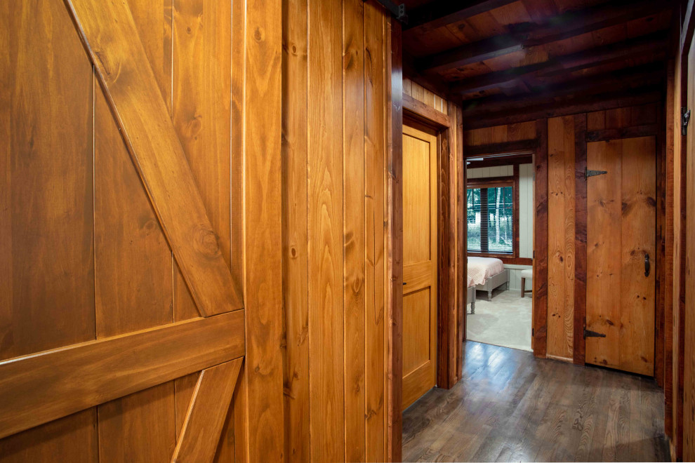 Small country hallway in Other with brown walls, medium hardwood floors, brown floor, exposed beam and panelled walls.