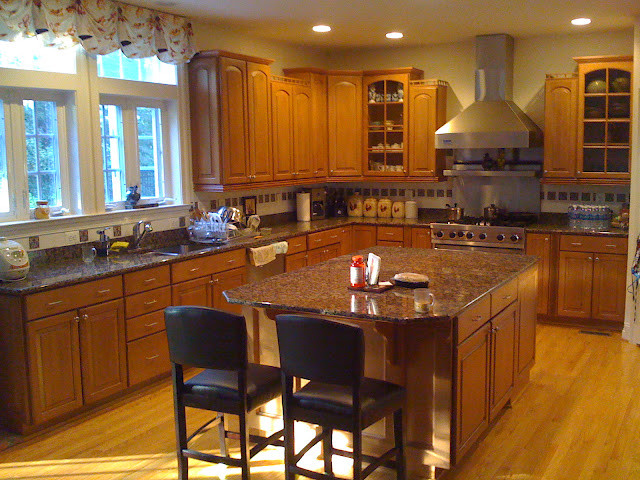 Example of a transitional kitchen design in DC Metro with beaded inset cabinets, medium tone wood cabinets, granite countertops, stainless steel appliances and an island