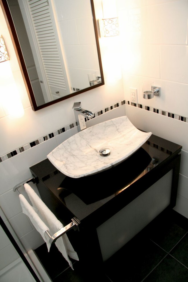 Mid-sized transitional 3/4 white tile and porcelain tile porcelain tile and black floor alcove shower photo with black cabinets, beige walls, a vessel sink, quartz countertops, a hinged shower door and black countertops