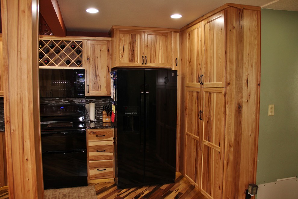 Inspiration for a large rustic l-shaped medium tone wood floor eat-in kitchen remodel in Minneapolis with an undermount sink, flat-panel cabinets, light wood cabinets, quartz countertops, black backsplash, glass tile backsplash, black appliances, red walls and no island