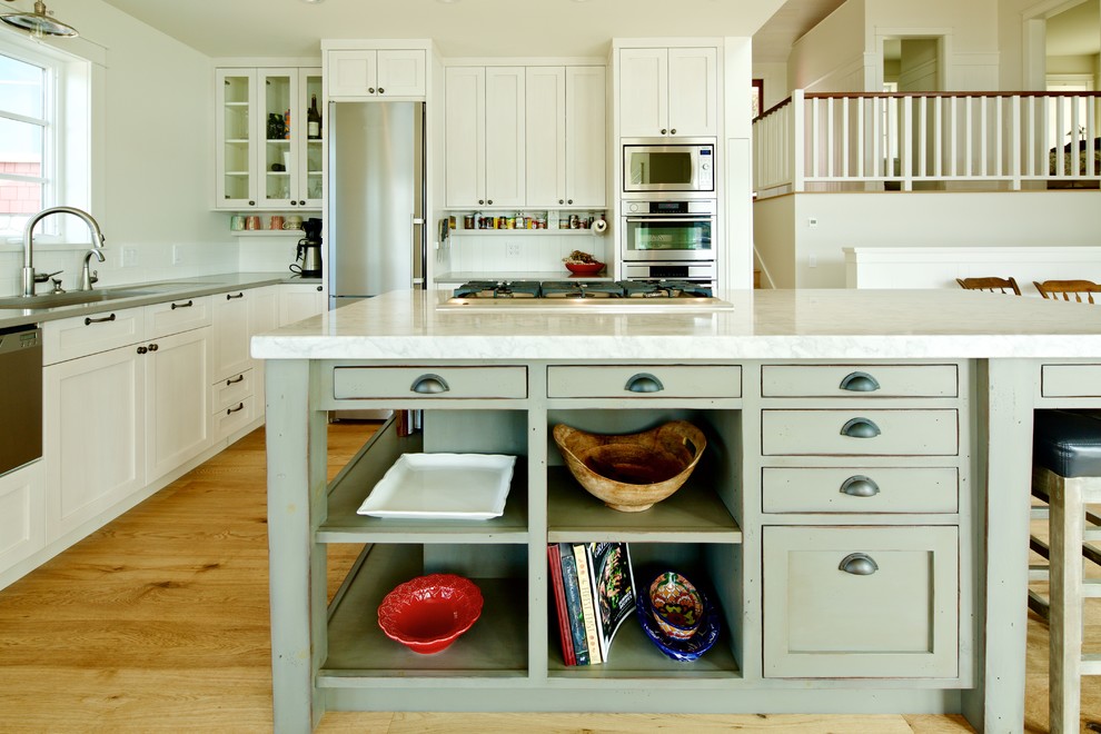 Inspiration for a large eclectic l-shaped open plan kitchen in Vancouver with shaker cabinets, green cabinets, with island, an undermount sink, quartzite benchtops, white splashback, subway tile splashback, stainless steel appliances and medium hardwood floors.