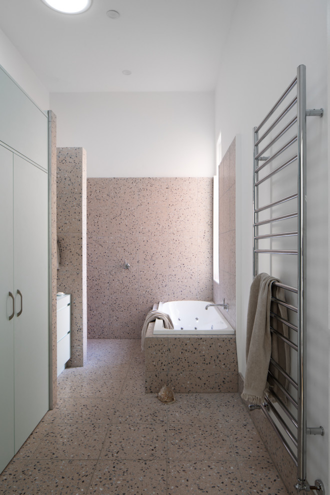 Inredning av ett eklektiskt mellanstort grön grönt en-suite badrum, med släta luckor, gröna skåp, ett platsbyggt badkar, en öppen dusch, en toalettstol med separat cisternkåpa, rosa kakel, stenkakel, rosa väggar, terrazzogolv, ett fristående handfat, laminatbänkskiva, rosa golv och med dusch som är öppen