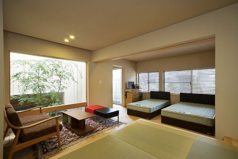 Mittelgroßes, Offenes Asiatisches Wohnzimmer mit weißer Wandfarbe, braunem Holzboden, Tapetendecke, freistehendem TV und Tapetenwänden in Nagoya