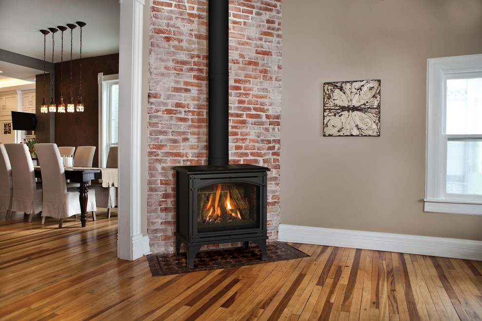 This is an example of a mid-sized industrial open concept family room in Minneapolis with beige walls, dark hardwood floors, a standard fireplace, a metal fireplace surround and no tv.