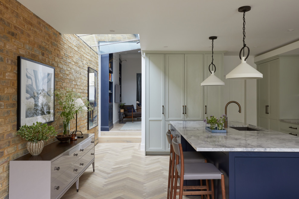 Zweizeilige, Mittelgroße Klassische Wohnküche mit Schrankfronten im Shaker-Stil, grünen Schränken, Rückwand aus Granit, Küchengeräten aus Edelstahl, hellem Holzboden, Kücheninsel und grauer Arbeitsplatte in London