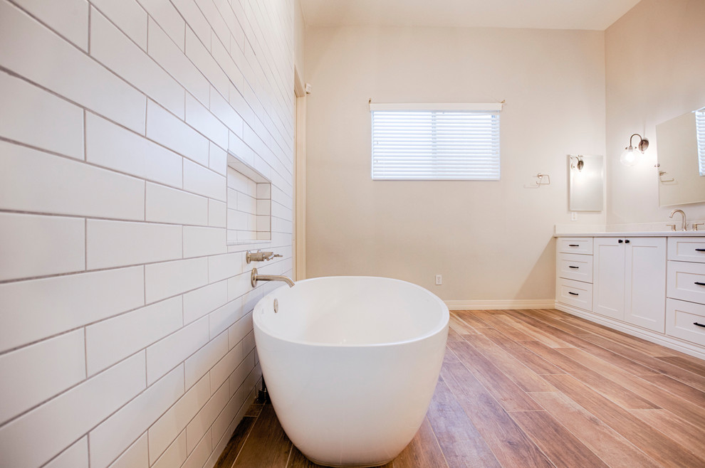 Photo of an expansive transitional master bathroom in Phoenix with shaker cabinets, white cabinets, a freestanding tub, an alcove shower, a two-piece toilet, brown tile, porcelain tile, grey walls, porcelain floors, an undermount sink and quartzite benchtops.