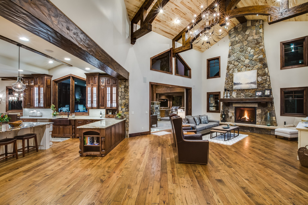 Open concept kitchen - huge rustic medium tone wood floor open concept kitchen idea in Denver with a farmhouse sink, raised-panel cabinets, dark wood cabinets, beige backsplash, stainless steel appliances and an island