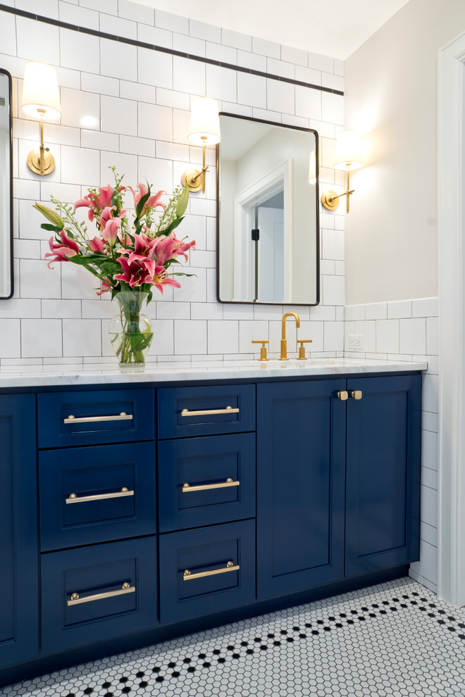 Photo of a transitional bathroom in Austin with recessed-panel cabinets, blue cabinets, white tile, subway tile, beige walls, mosaic tile floors, an undermount sink, multi-coloured floor and white benchtops.