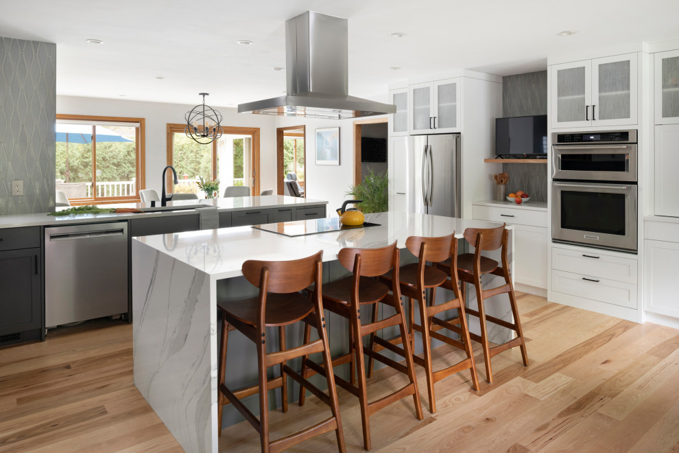 Inspiration for a transitional l-shaped kitchen in Minneapolis with white cabinets, grey splashback, stainless steel appliances, with island and white benchtop.