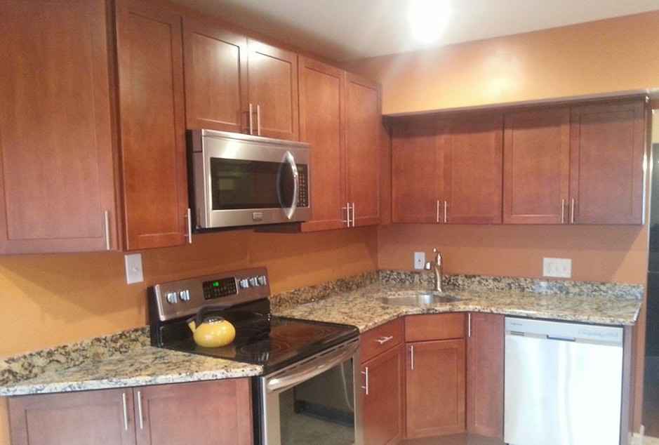 Example of a mid-sized transitional l-shaped kitchen design in Baltimore with an undermount sink, shaker cabinets, medium tone wood cabinets, granite countertops, stainless steel appliances and no island