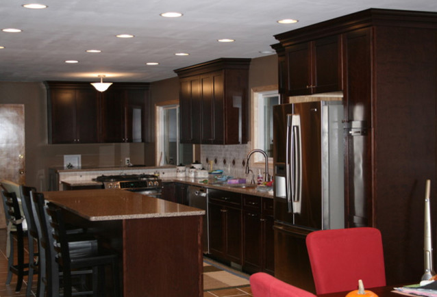 Trendy limestone floor and beige floor kitchen photo in Phoenix with an undermount sink, shaker cabinets, dark wood cabinets, quartz countertops, beige backsplash, travertine backsplash, stainless steel appliances and an island