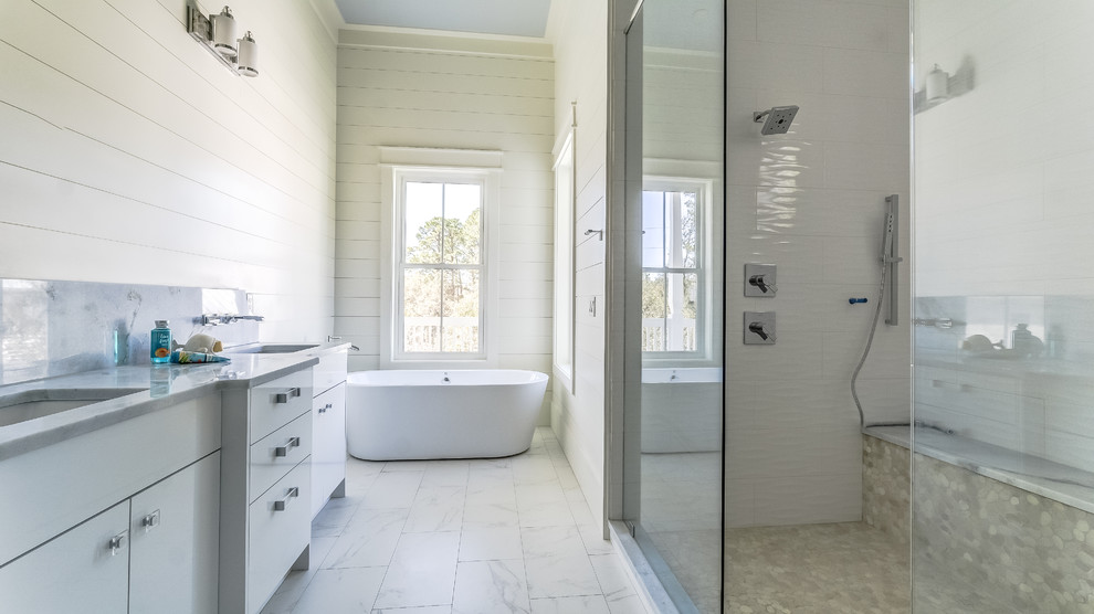 Design ideas for an expansive beach style master bathroom in Miami with white walls, flat-panel cabinets, white cabinets, a freestanding tub, an alcove shower, marble floors, an undermount sink, marble benchtops, white floor, an open shower and grey benchtops.