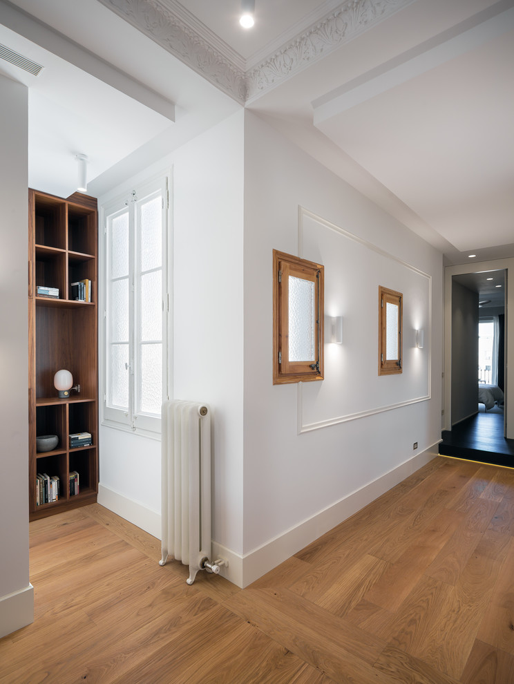Inspiration for a contemporary hallway in Barcelona with white walls and medium hardwood floors.