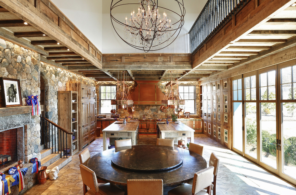Photo of an expansive country kitchen/dining combo in New York with multi-coloured walls, a stone fireplace surround, a standard fireplace and light hardwood floors.
