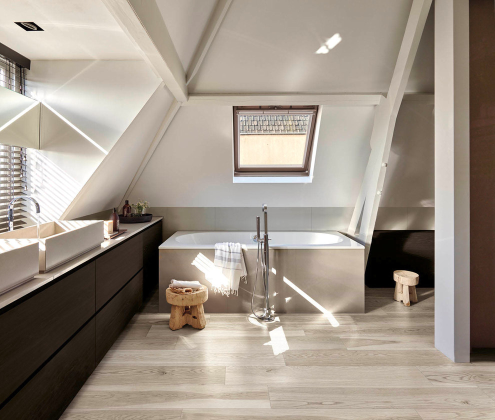 Design ideas for a contemporary bathroom in Perth with flat-panel cabinets, dark wood cabinets, a drop-in tub, porcelain tile, white walls, porcelain floors, a vessel sink and solid surface benchtops.