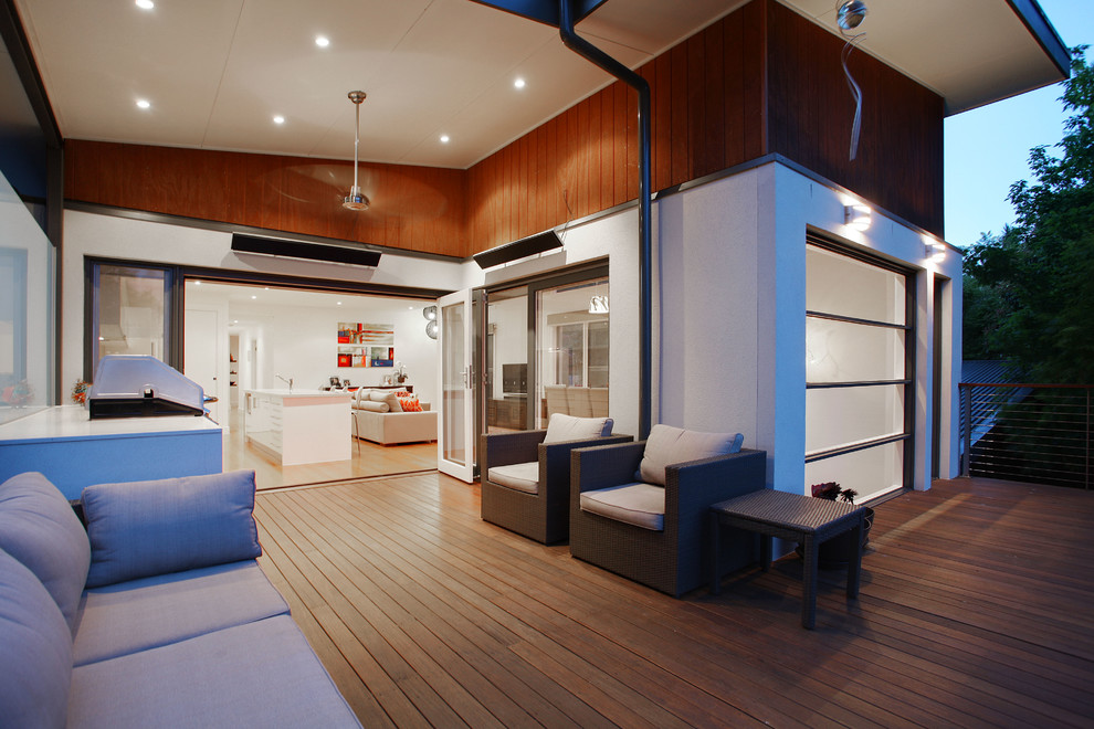 This is an example of a mid-sized contemporary backyard deck in Melbourne with a roof extension.