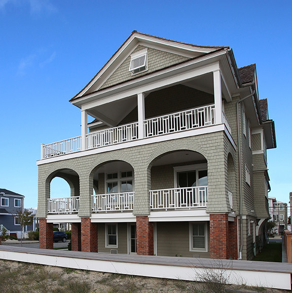 This is an example of a mid-sized beach style two-storey beige exterior in Philadelphia with wood siding and a gable roof.