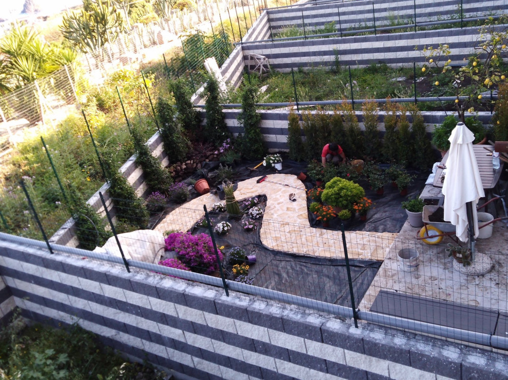 Idée de décoration pour un jardin arrière minimaliste de taille moyenne et l'été avec une exposition ensoleillée, des pavés en pierre naturelle et une clôture en métal.
